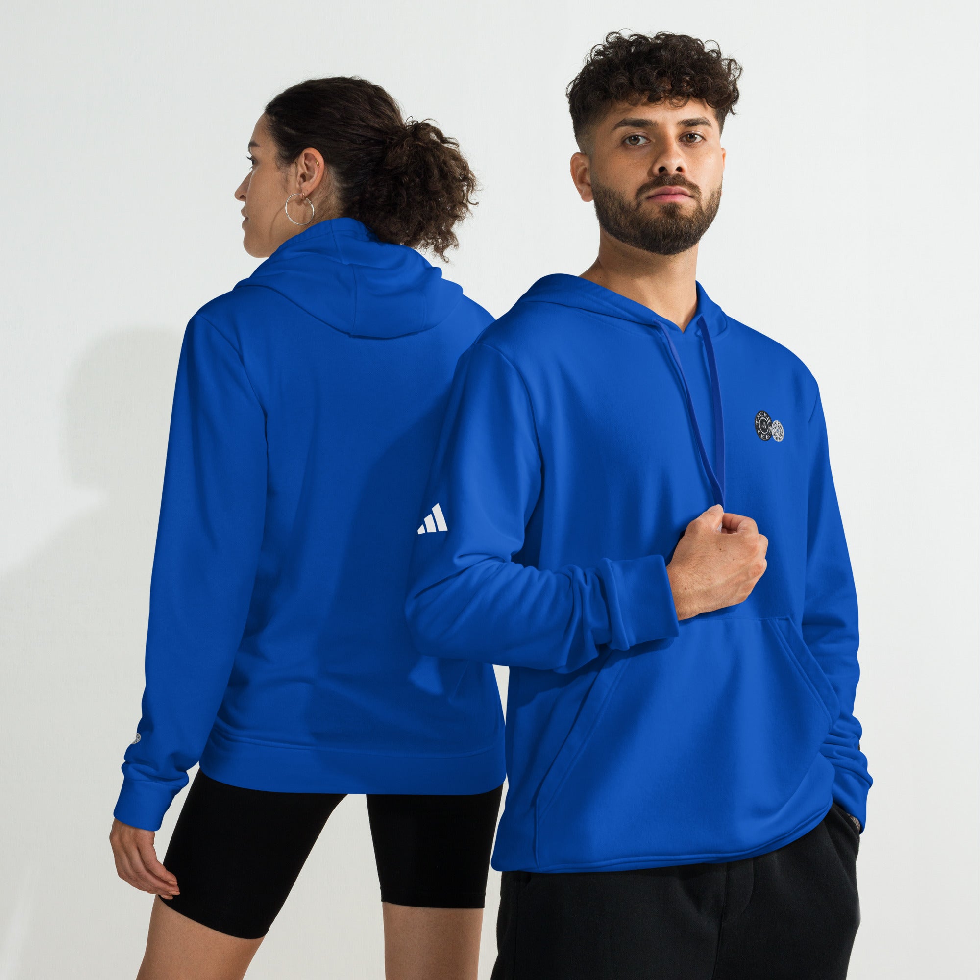 Man and woman wearing blue adidas x Signature embroidered fleece hoodies with comfy design and sporty branding