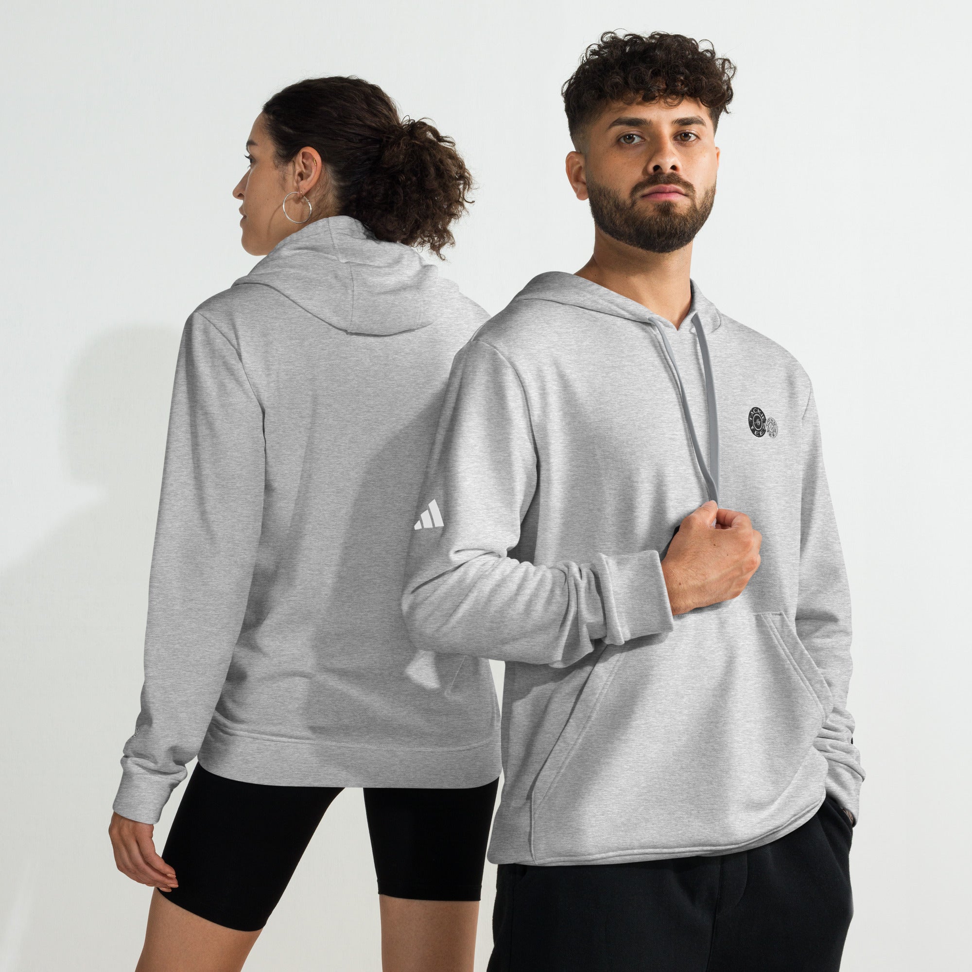 Two models wearing grey adidas x Signature embroidered fleece hoodies, showcasing front and back views. Comfy, sporty hoodie sweatshirt.