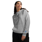 Woman wearing Under Armour x Signature embroidered hoodie, showcasing its relaxed fit and comfortable fleece material.