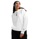 Woman wearing Under Armour® x Signature embroidered white hoodie, showcasing its relaxed fit and luxurious soft fleece for all-day comfort.