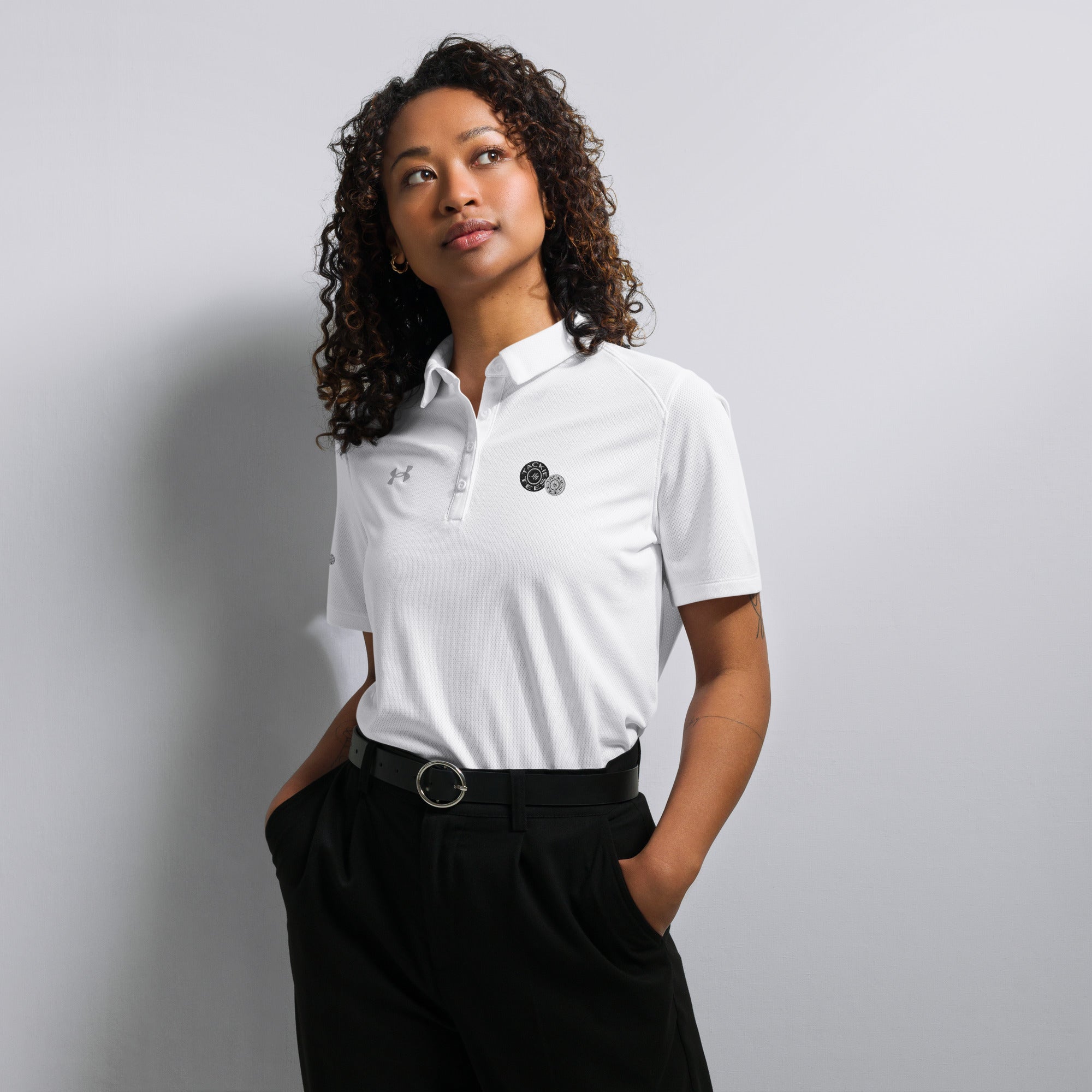 Woman wearing Under Armour x Signature embroidered white polo standing against a white background.